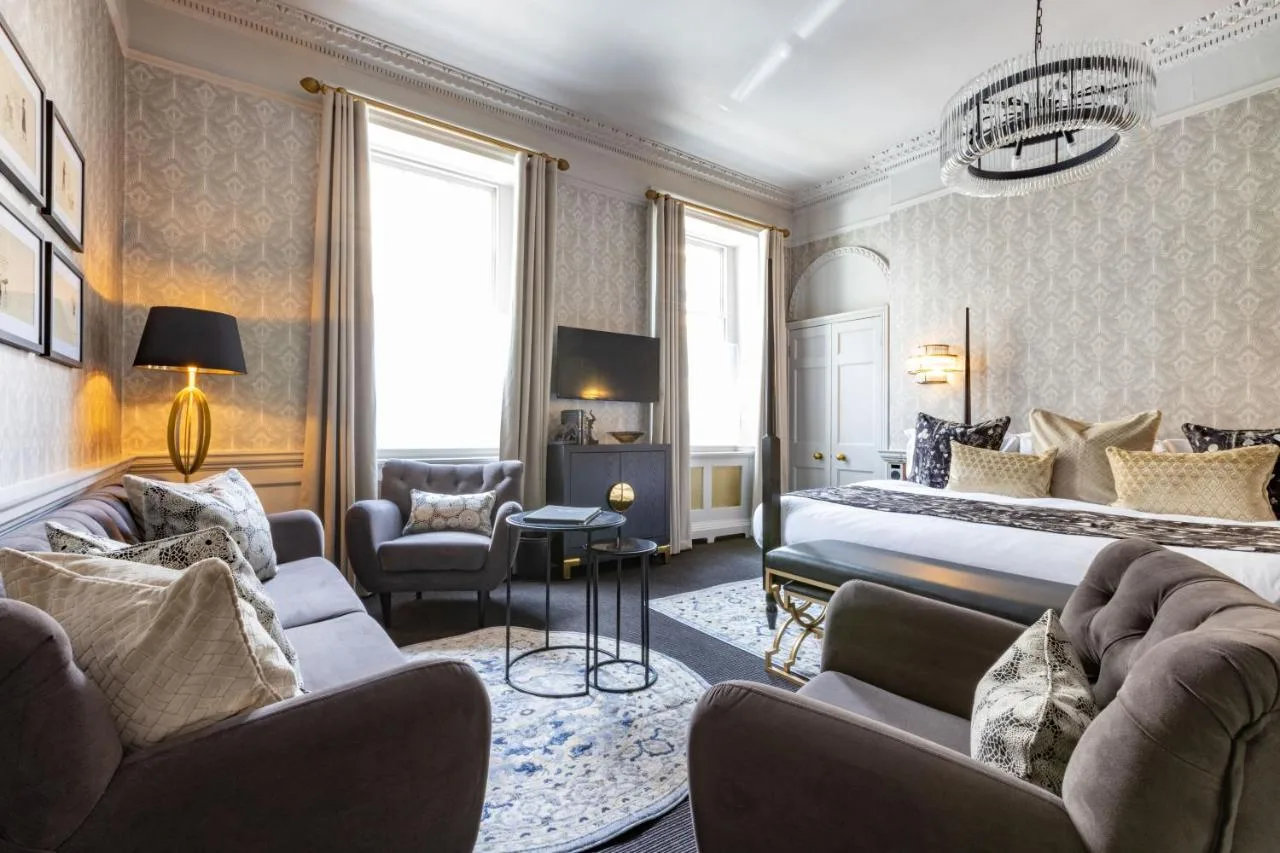 A hotel room with a bed and two couches at The Queensberry Hotel in Bath